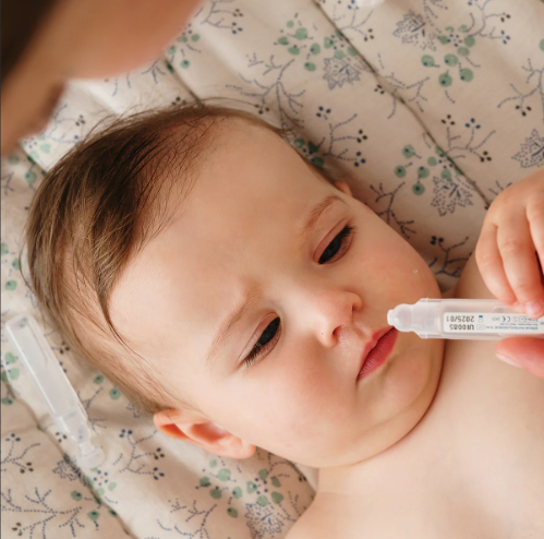 putting saline eye wash to baby